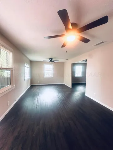 a view of empty room with wooden floor