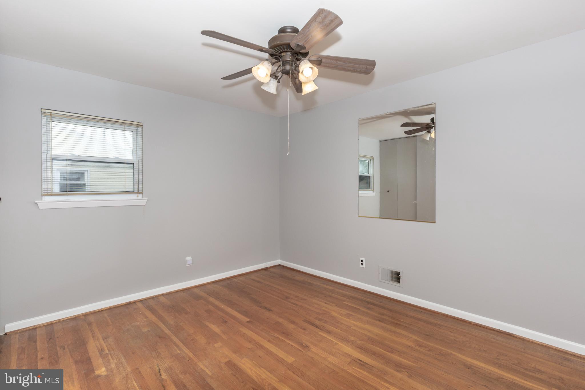 520 Crisfield Road Baltimore, MD 21220 - Photo 18 of 27 a view of an empty room with wooden floor and a chandelier fan
