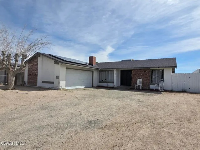 front view of a house with a yard and garage