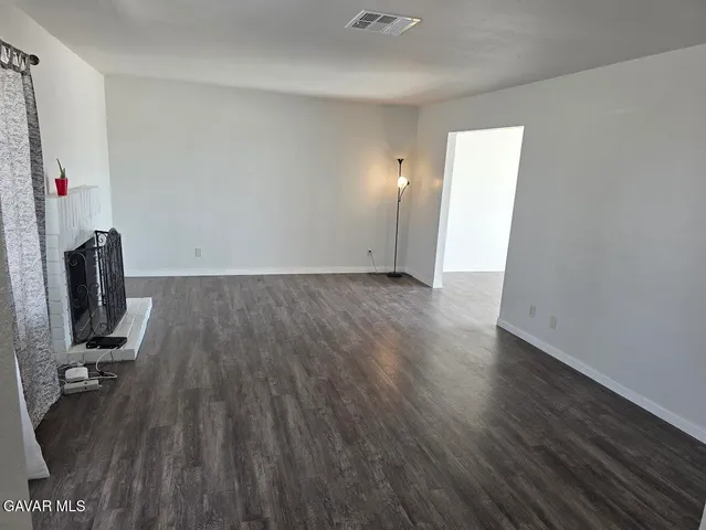 a view of a room with wooden floor and a sink