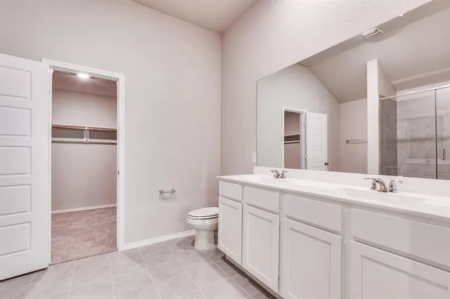 a bathroom with a double vanity sink toilet and mirror