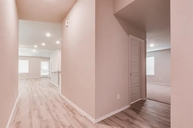 a view of a hallway with wooden floor