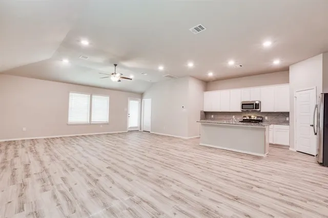 a view of kitchen with granite countertop cabinets and refrigerator