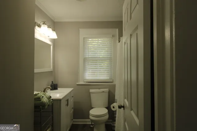 a bathroom with a toilet sink and mirror