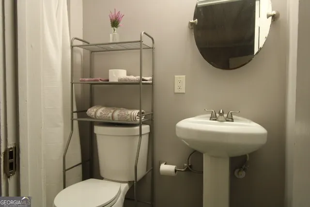 a bathroom with a toilet sink and mirror