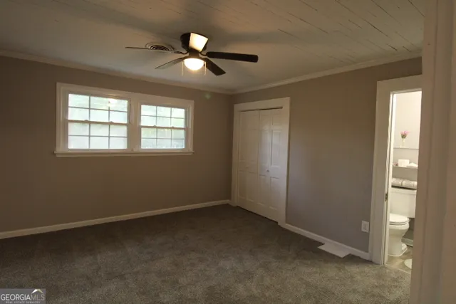 an empty room with windows and fan