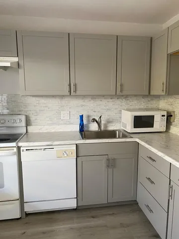 a kitchen with cabinets appliances a sink and a counter top space