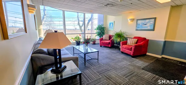 a view of workspace with lounge chair and windows