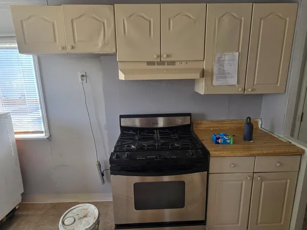 a kitchen with granite countertop white cabinets and a stove