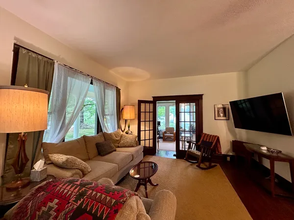 a living room with furniture a flat screen tv and a large window