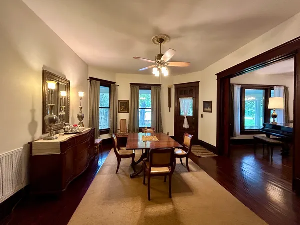 a dining room with furniture a fireplace and wooden floor