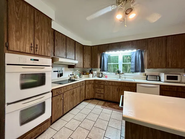 a kitchen with kitchen island a sink stove and refrigerator