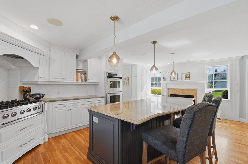 183 Whiting Street Hanover, MA 02339 - Photo 5 of 42 a kitchen with a table chairs and white cabinets