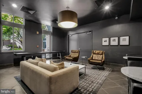 a living room with furniture and a painting on the wall