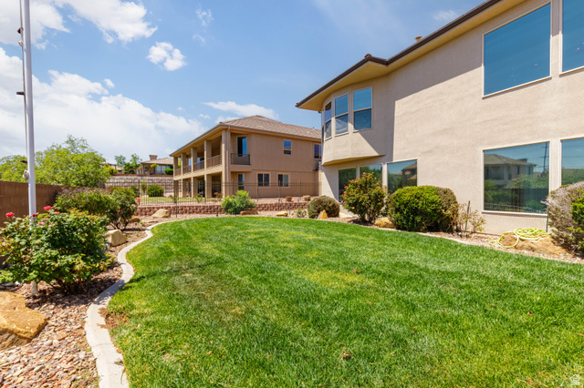 2005 West 450 S Circle St. George, UT 84770 - Photo 40 of 57 Expansive backyard featuring a manicured lawn, established landscaping, and a curved concrete border