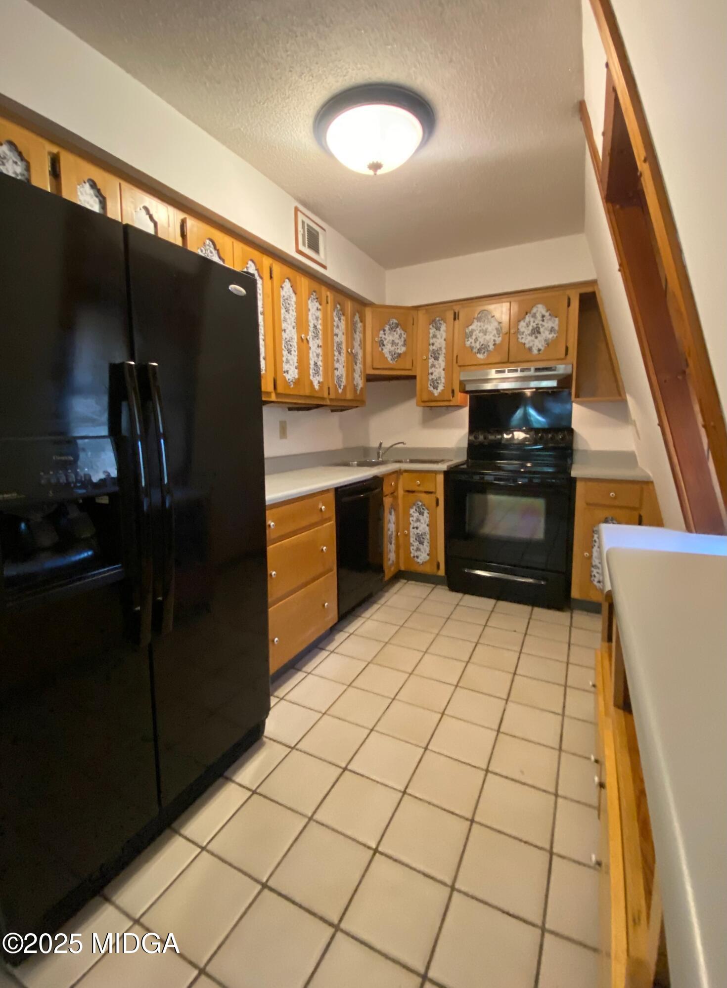 231 West Seminole Drive Byron, GA 31008 - Photo 7 of 38 a kitchen with granite countertop a refrigerator and a stove top oven