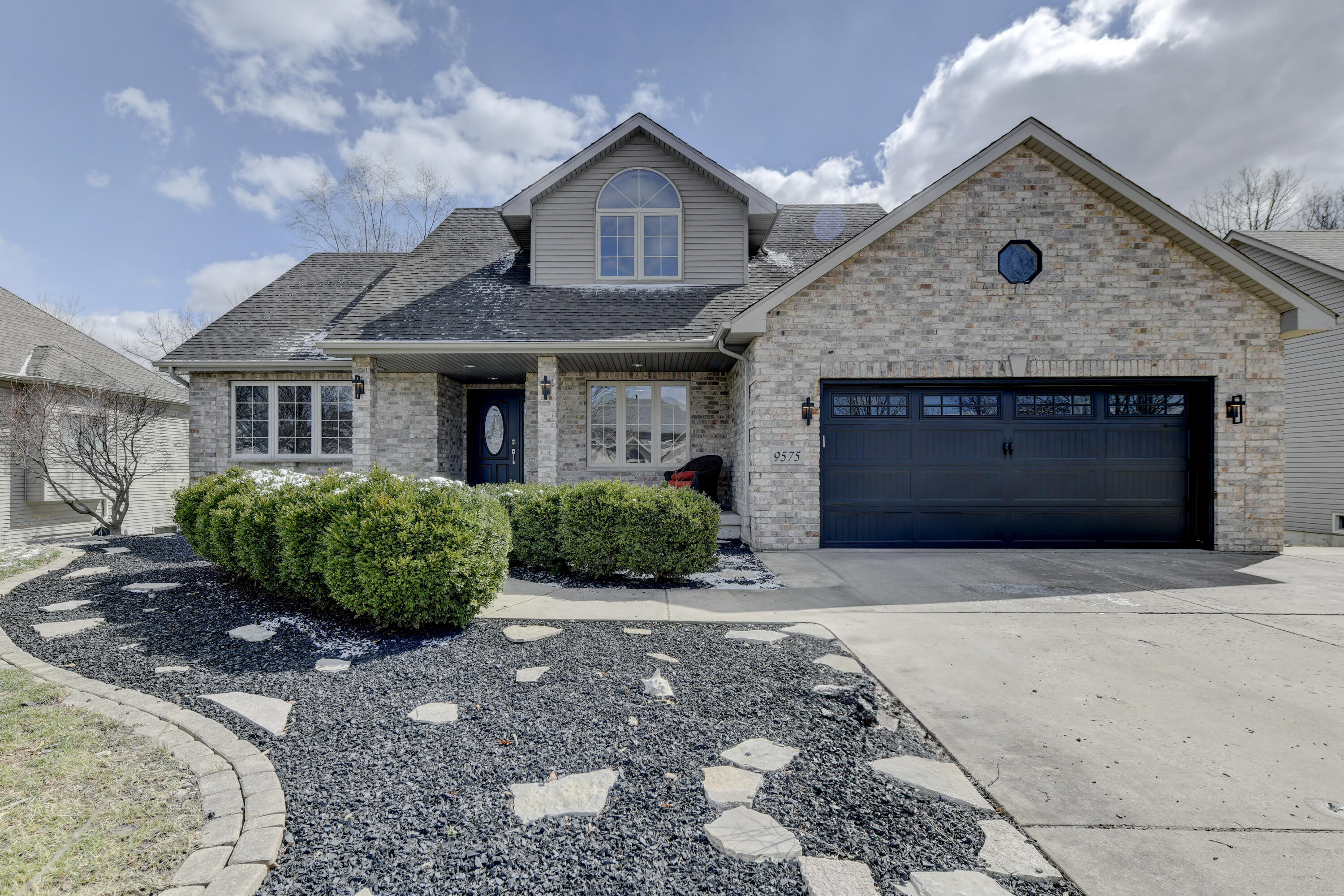 a front view of a house with a yard and garage