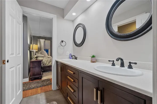 a en suite bathroom with a granite countertop double vanity sinks and a mirror