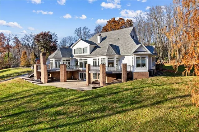 a view of a house with a big yard and large trees