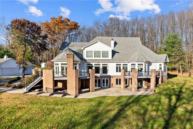 a view of a house with a big yard and large trees
