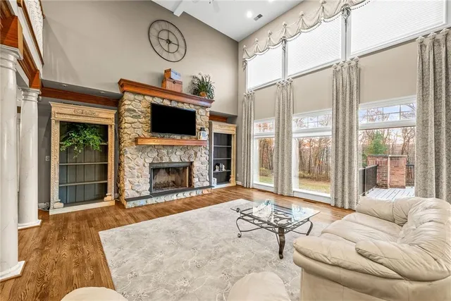a living room with furniture a fireplace and a floor to ceiling window