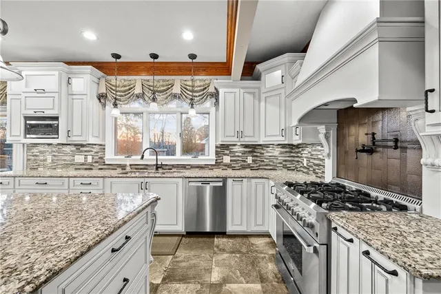 a kitchen with stainless steel appliances granite countertop a sink stove and refrigerator