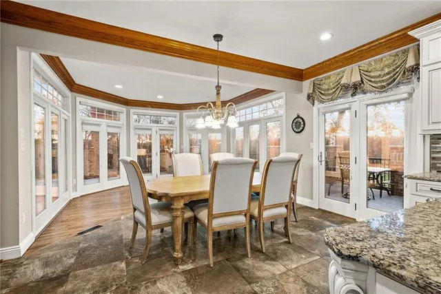 a dining room with furniture a chandelier and wooden floor