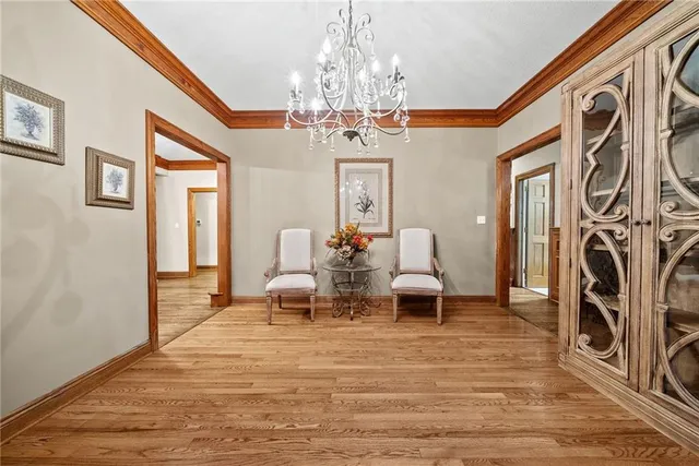a view of a dining room with furniture a chandelier and wooden floor
