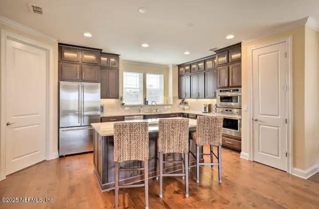 168 Lawn Avenue St. Augustine, FL 32084 - Photo 12 of 36 a kitchen with stainless steel appliances kitchen island granite countertop a refrigerator and a stove top oven