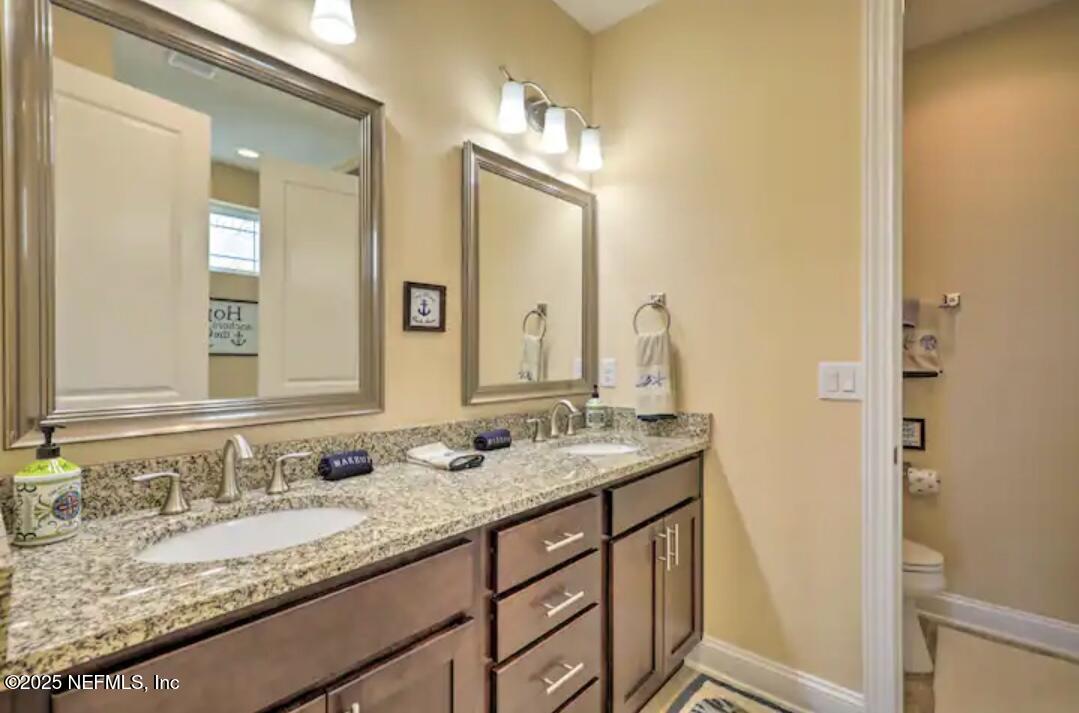168 Lawn Avenue St. Augustine, FL 32084 - Photo 22 of 36 a bathroom with a granite countertop sink and a mirror