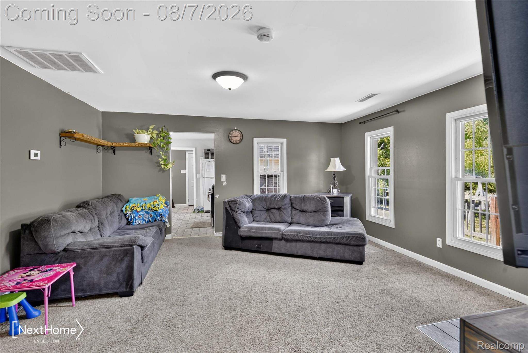 23740 Carleton West Road Belleville, MI 48111 - Photo 10 of 58 Spacious recreation room featuring plush seating, neutral carpet flooring, and abundant natural light from multiple glass doors and windows