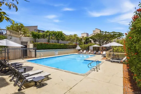 a view of a swimming pool with lounge chairs in patio