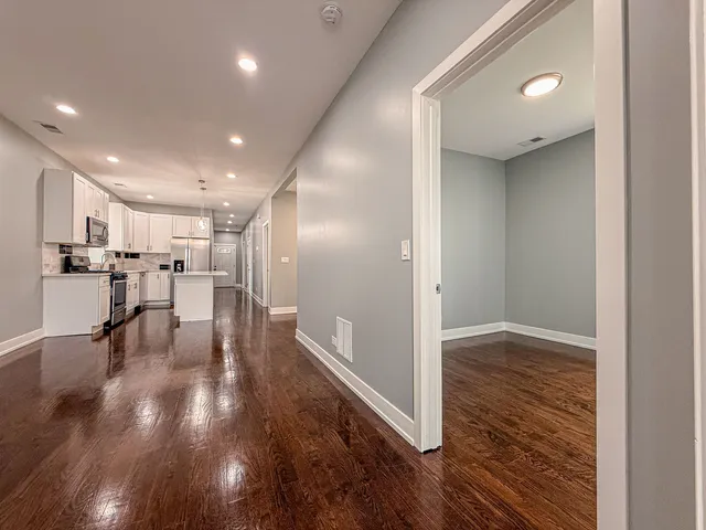 a view of empty room with wooden floor