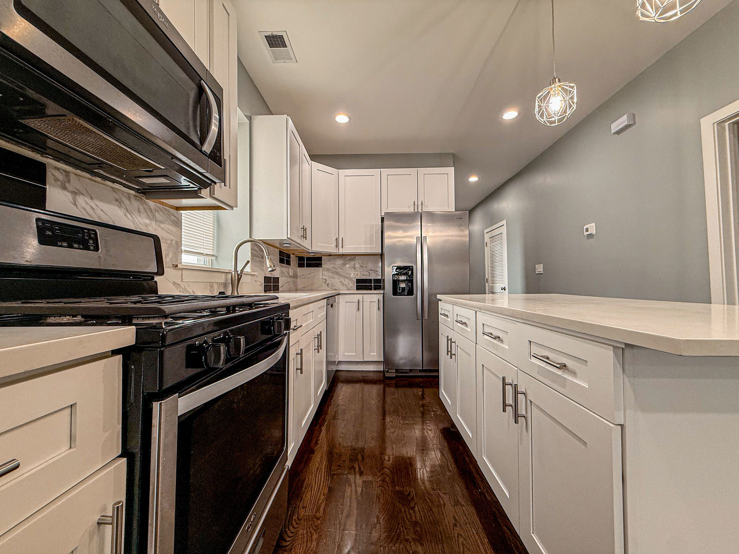 4817 West Jackson Boulevard, Unit 2 Chicago, IL 60644 - Photo 5 of 20 a kitchen with white cabinets and stainless steel appliances