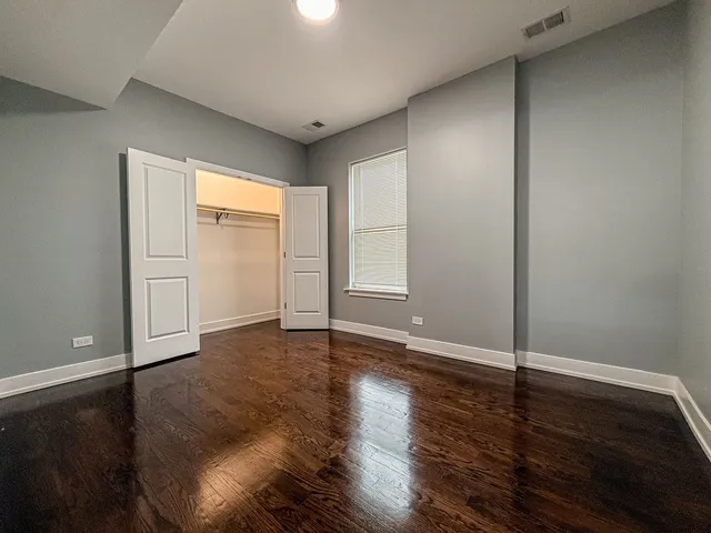 an empty room with wooden floor and closet