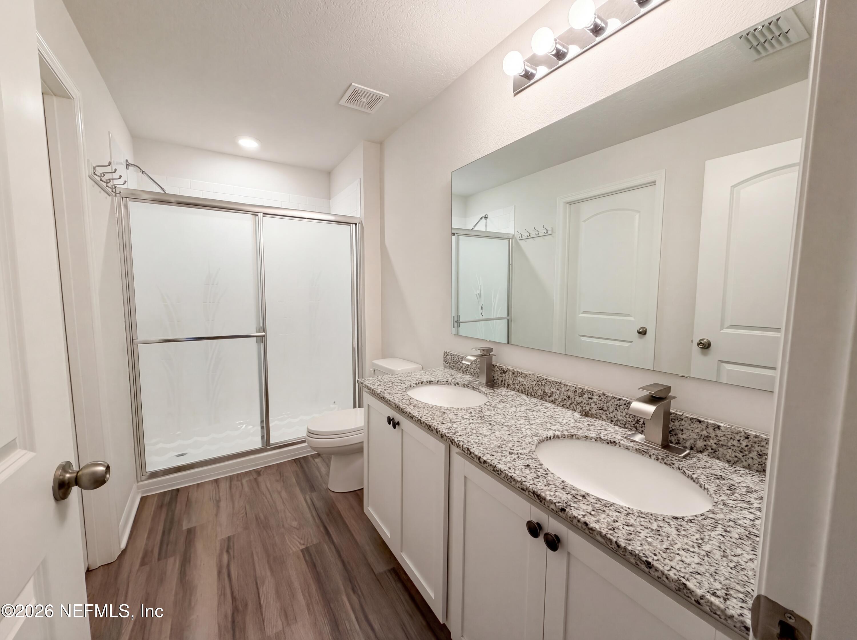 171 River Ridge Welaka, FL 32193 - Photo 14 of 17 a bathroom with a granite countertop sink a mirror and a shower