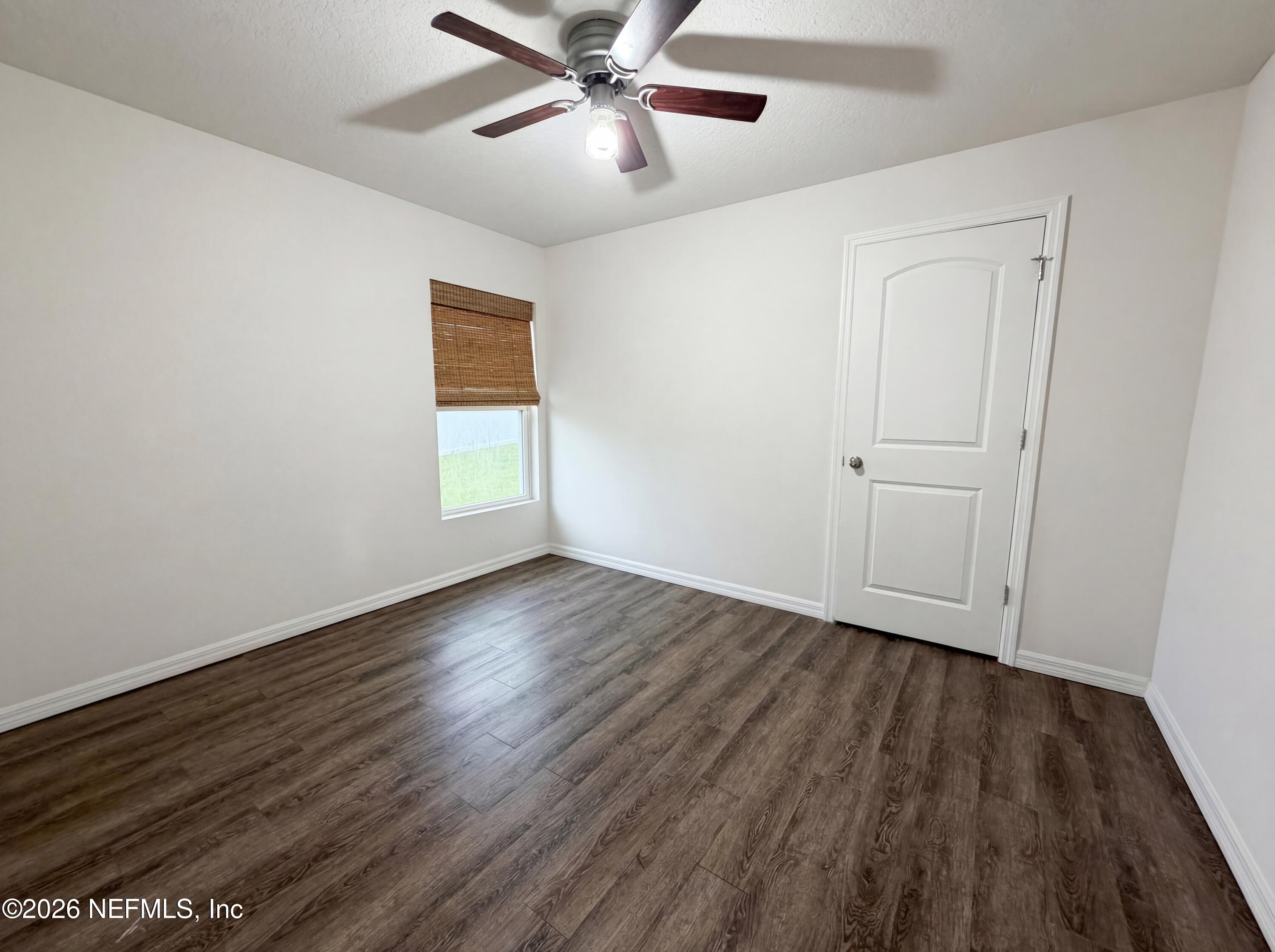 171 River Ridge Welaka, FL 32193 - Photo 10 of 17 an empty room with wooden floor chandelier fan and windows