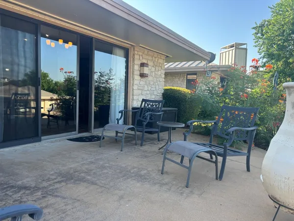 a view of patio with a table and chairs and potted plants