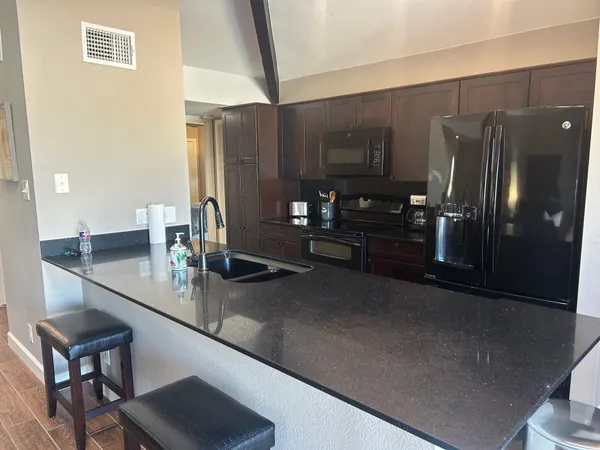 a kitchen with refrigerator and chairs