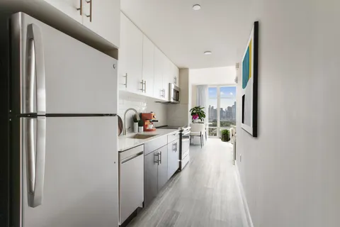 a kitchen with a refrigerator and white cabinets