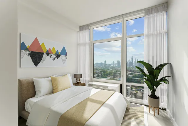 a bedroom with a large bed and a potted plant