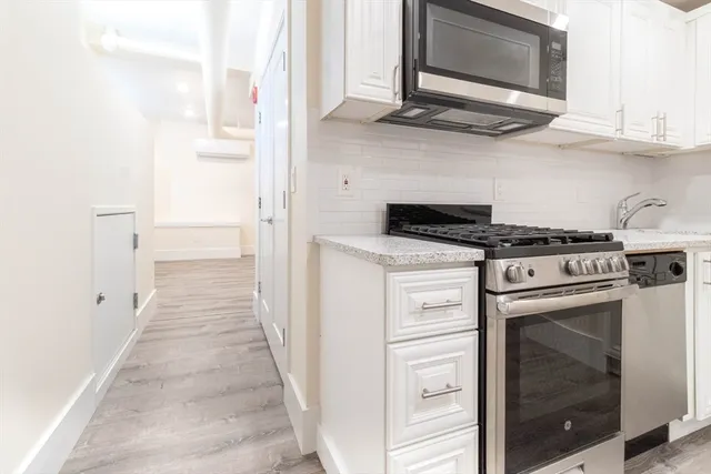 a kitchen with stainless steel appliances granite countertop a stove and a microwave