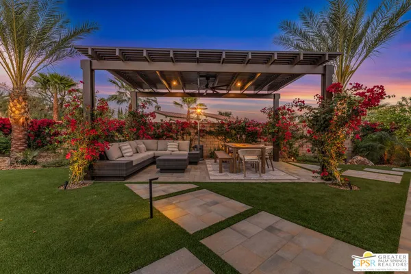 a view of a big house with a big yard and potted plants