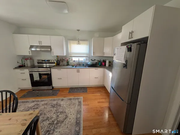 a kitchen with granite countertop a refrigerator stove and sink
