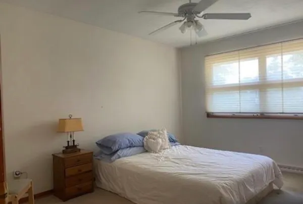 a bedroom with a bed chair and wall painting