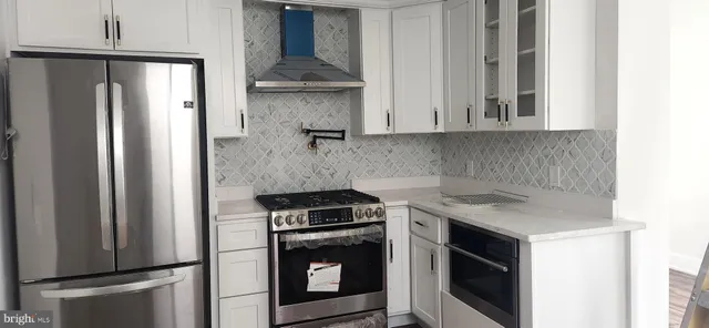 a kitchen with stainless steel appliances granite countertop a refrigerator sink and stove