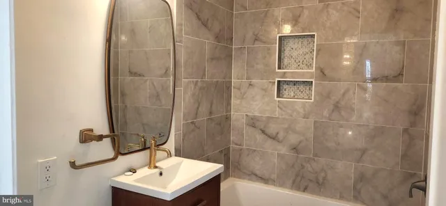 a bathroom with a sink mirror and shower
