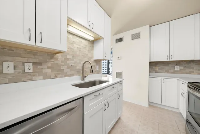 a kitchen with a sink dishwasher and cabinets
