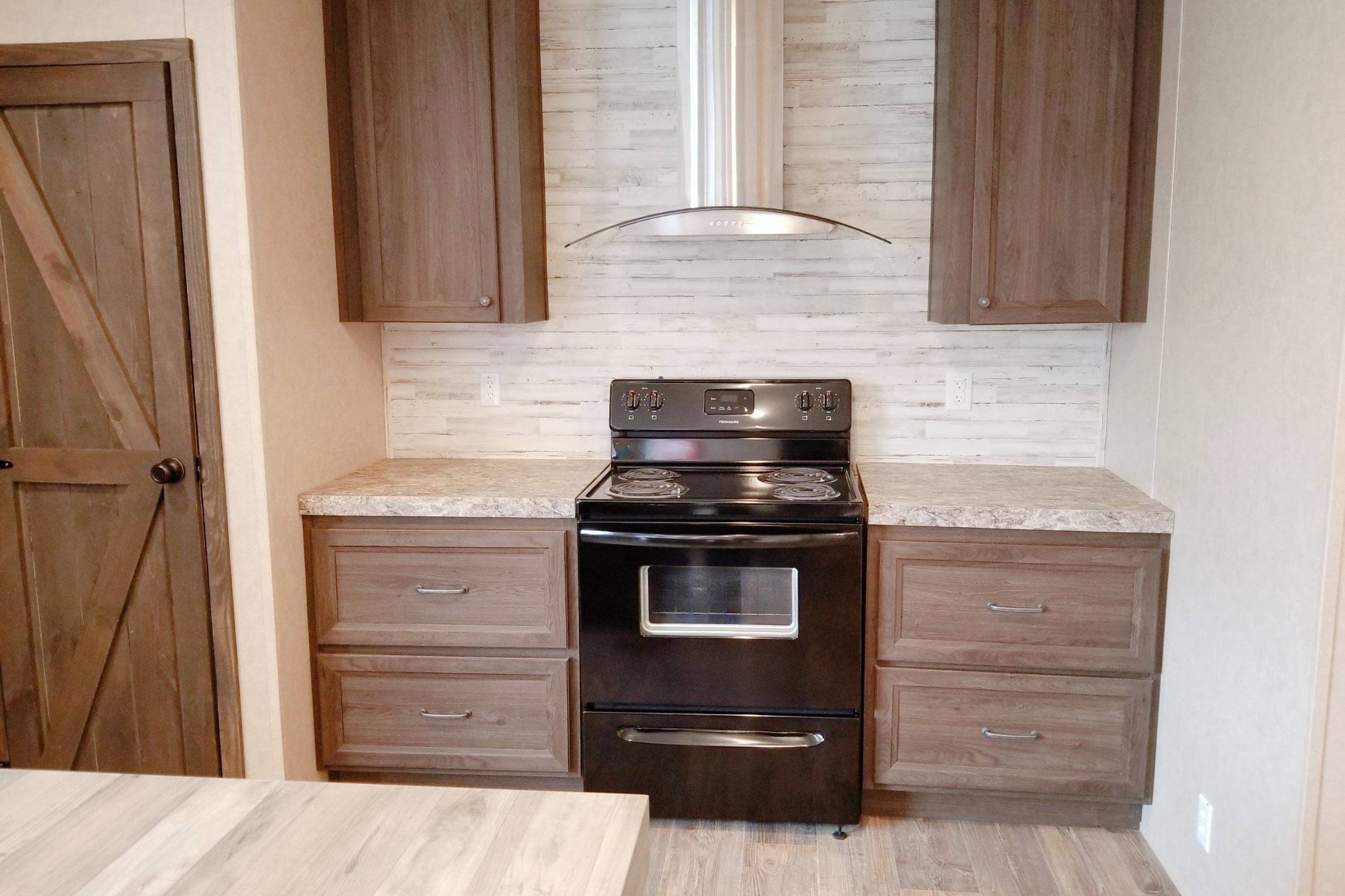 2409 County Road 313 Jarrell, TX 76537 - Photo 7 of 14 Kitchen featuring black electric range oven, backsplash, wood finish cabinetry, and light wood-style floors