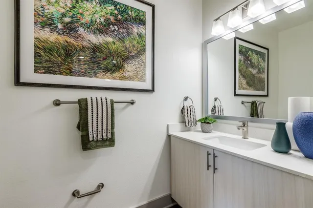 a bathroom with a sink mirror and vanity